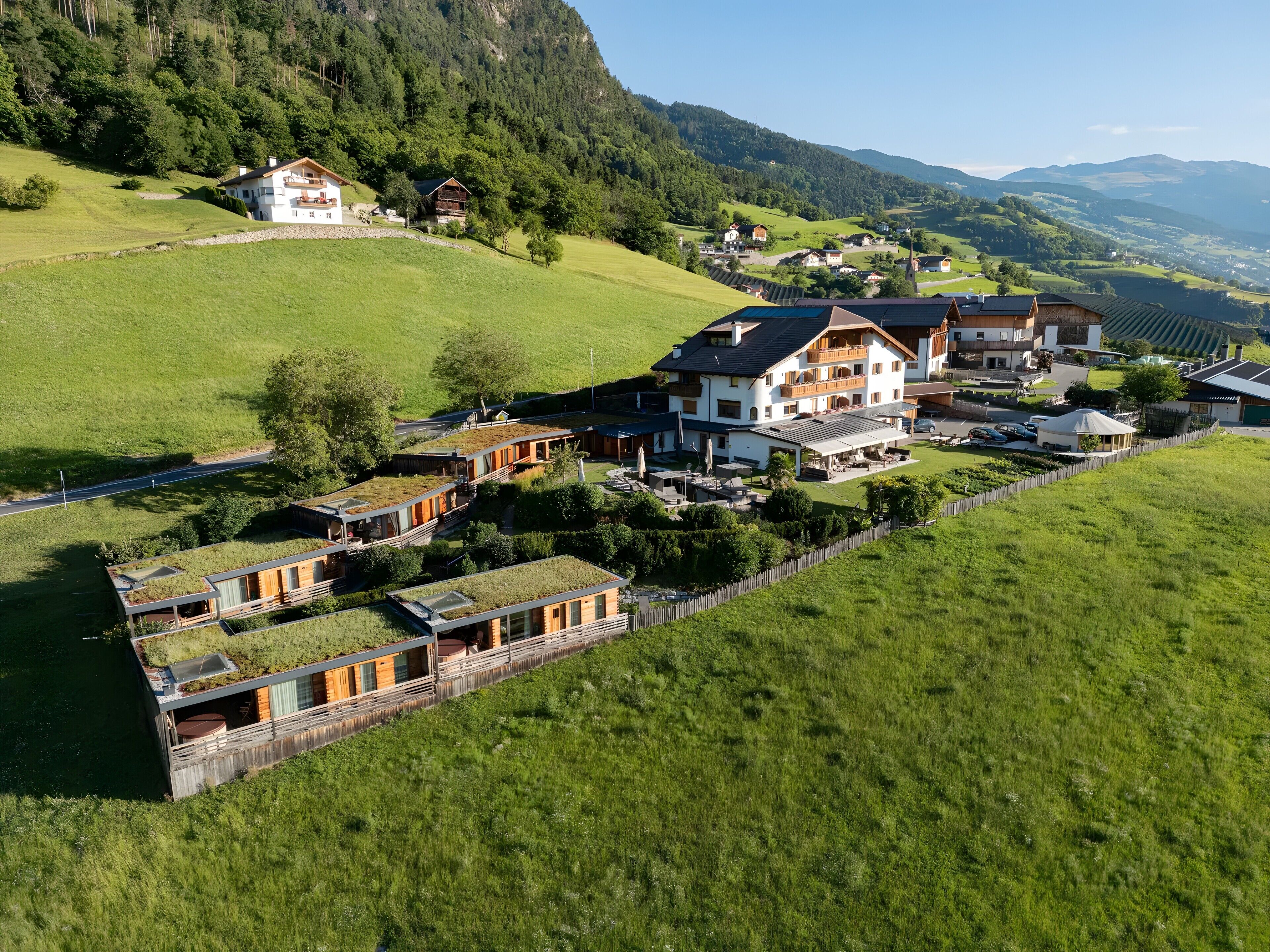 A residential area with houses, a road, and a hilly landscape.
