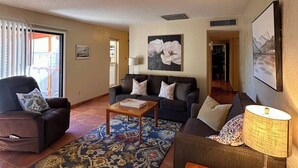 A living room with a sofa, armchair, coffee table, and a rug. - 2 bed/1 bath near NMSU, pets welcome (Las Cruces)