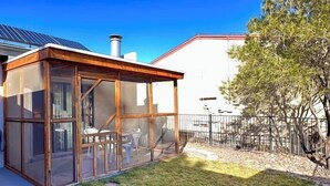 A modern house with a glass-enclosed patio, a solar panel, and a stone pathway leading to the door. - 2 bed/1 bath near NMSU, pets welcome (Las Cruces)