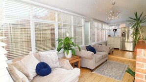 A modern living room with a beige sofa, a coffee table, and a potted plant. - Ivy's End (Loughborough)