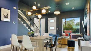 Un intérieur moderne comprenant un coin repas, un escalier et de grandes fenêtres.