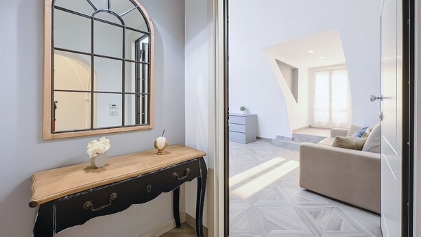 A modern interior with a wooden console table, a large mirror, and a geometric-patterned floor. - Bed and Breakfast 'Appartamento - Orchidea Celeste' with Sea View, Wi-Fi and Air Conditioning (Manfredonia)
