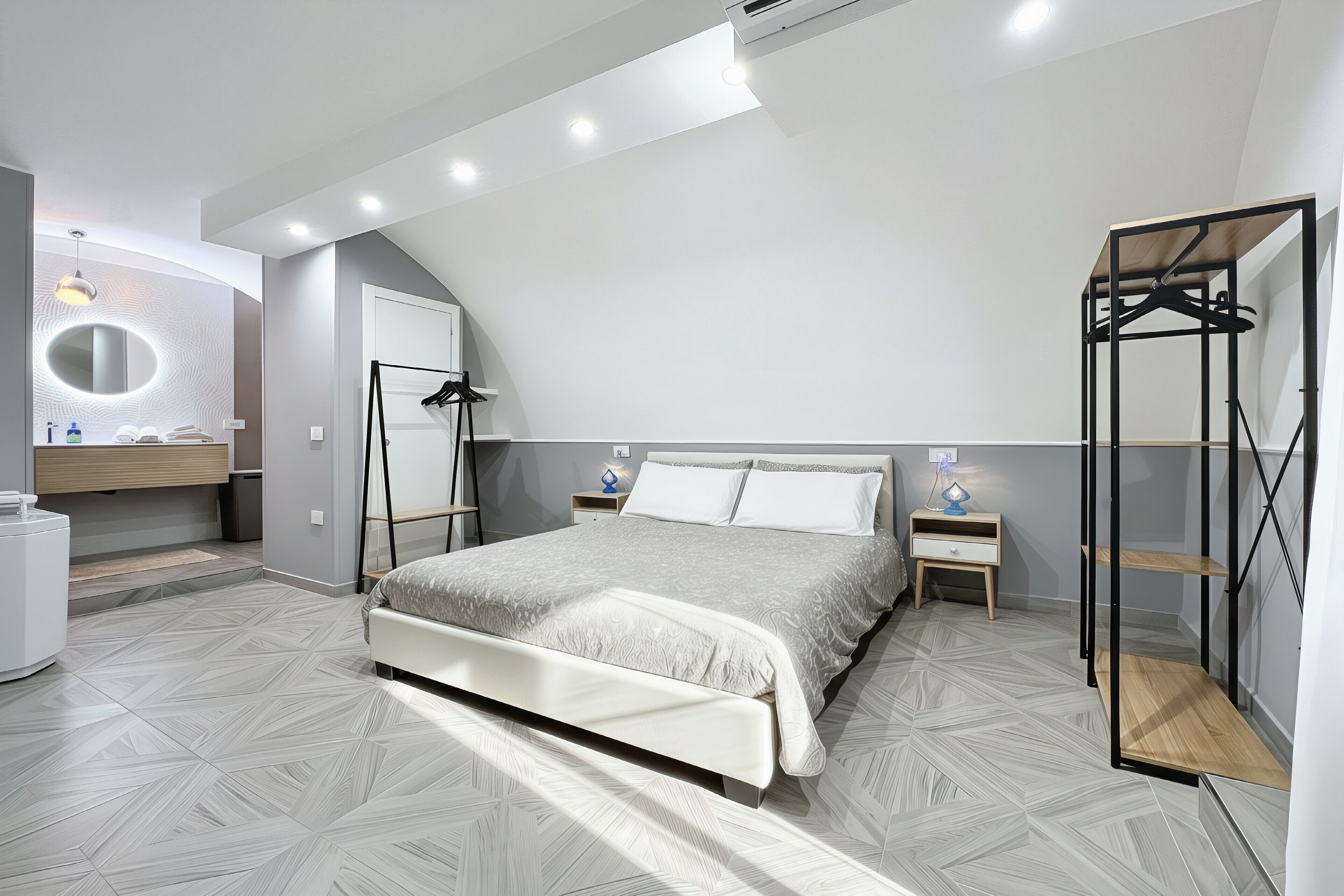 Une chambre à coucher avec un lit, des tables de chevet, un miroir et une armoire.