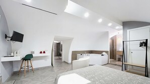 A modern hotel room with a bed, desk, chair, and a bathroom with a bathtub. - Bed and Breakfast 'Appartamento - Orchidea Celeste' with Sea View, Wi-Fi and Air Conditioning (Manfredonia)
