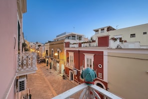A narrow street with buildings on either side, balconies, and a clear sky. - Triple Room 'Orchidea Celeste' with Sea View, Wi-Fi and Air Conditioning (Manfredonia)