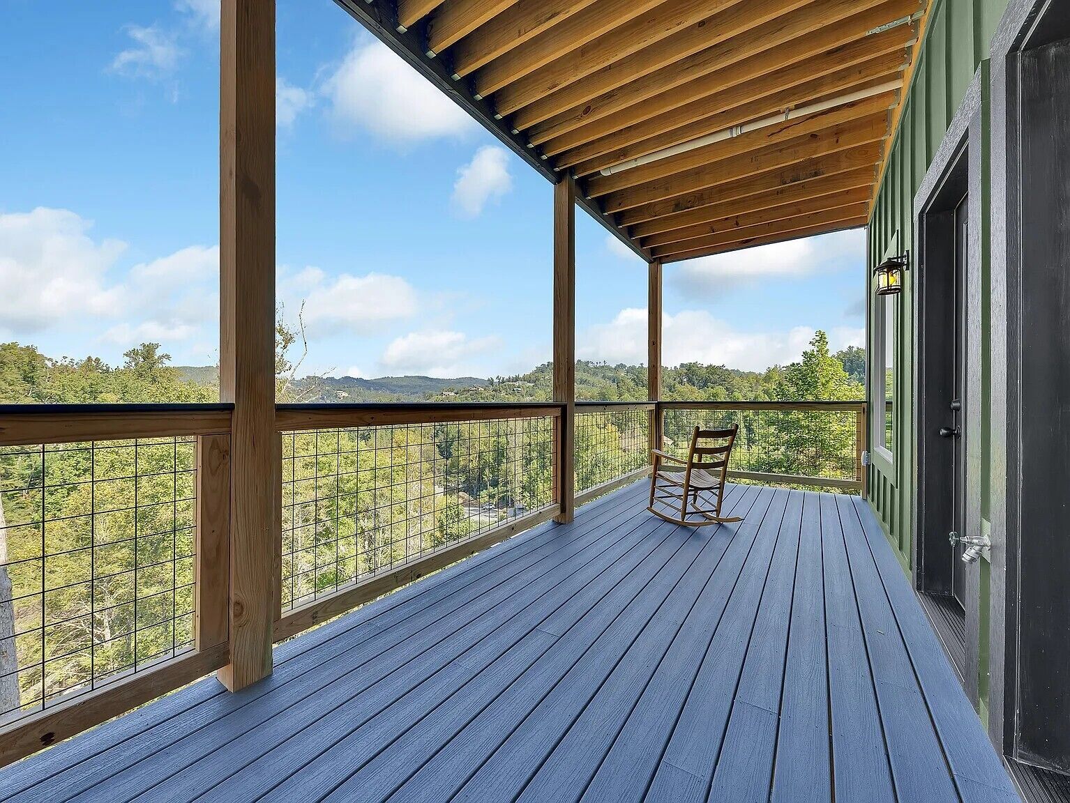 A wooden deck with a view of a forested landscape.