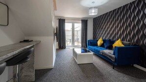Ein modernes Wohnzimmer mit einem blauen Sofa, einem Couchtisch und einer Wand mit Muster.