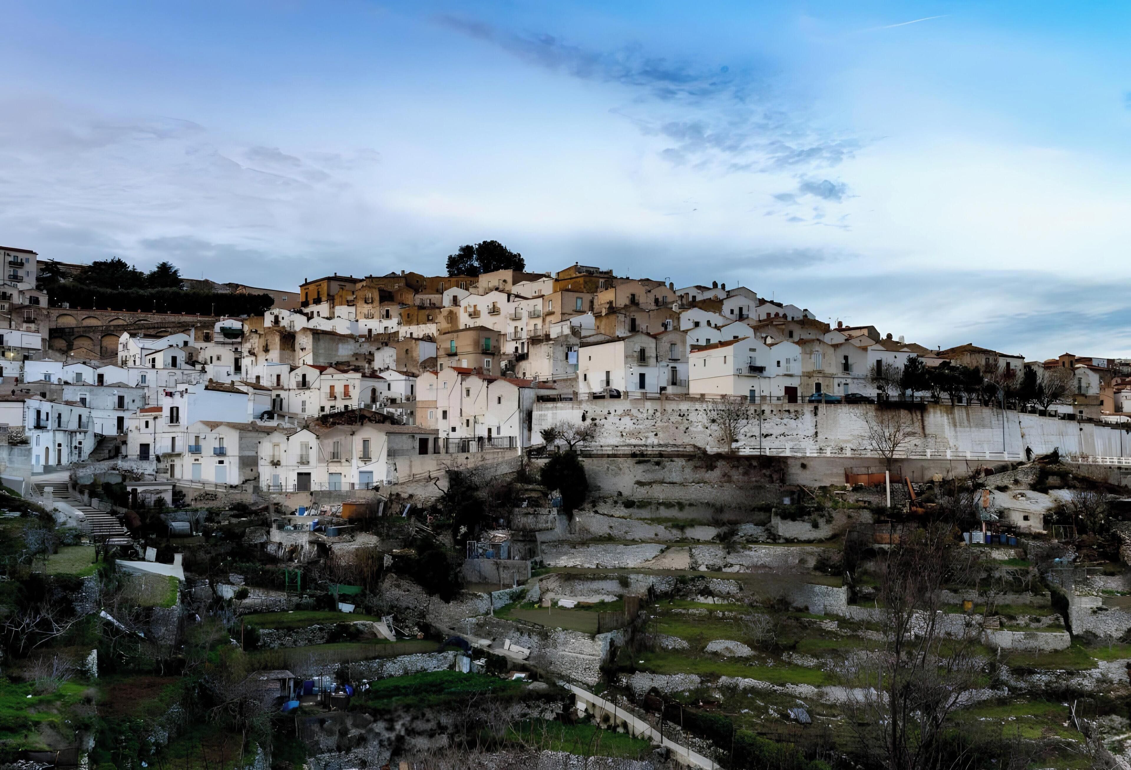 Un asentamiento en una ladera con arquitectura tradicional, campos en terrazas y un puente.