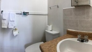 Een badkamer met een bad, toilet en wastafel.