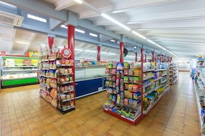 A supermarket aisle with shelves stocked with various products, a refrigerated section, and a checkout area. - Good Standard Furnished Chalet on Nice Park (Castellet i la Gornal)