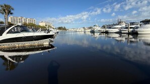 A marina with boats docked, calm water, and a hotel in the background. - 1st Floor Golf View Condo, Free Beach Shuttle, pool/ Hot Tub, Barefoot Landing (North Myrtle Beach)