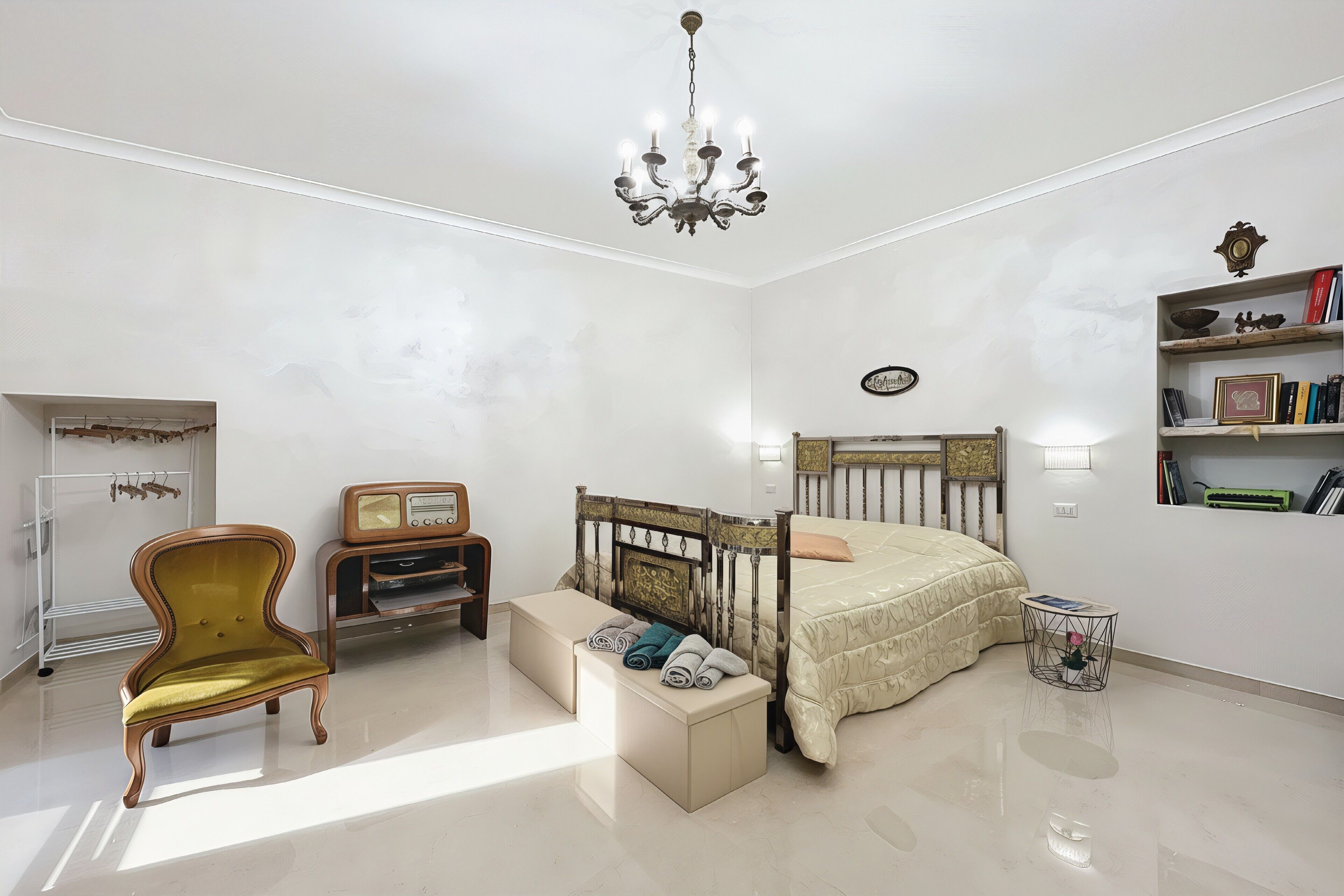 Una camera da letto con un letto, una toeletta, una sedia, un comodino, una libreria e un lampadario.