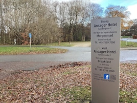 Señal para el Hotel Ansager con información de contacto y un código QR.