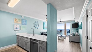 Una cocina moderna con una isla grande, un comedor con vistas y una sala de estar con sofá.