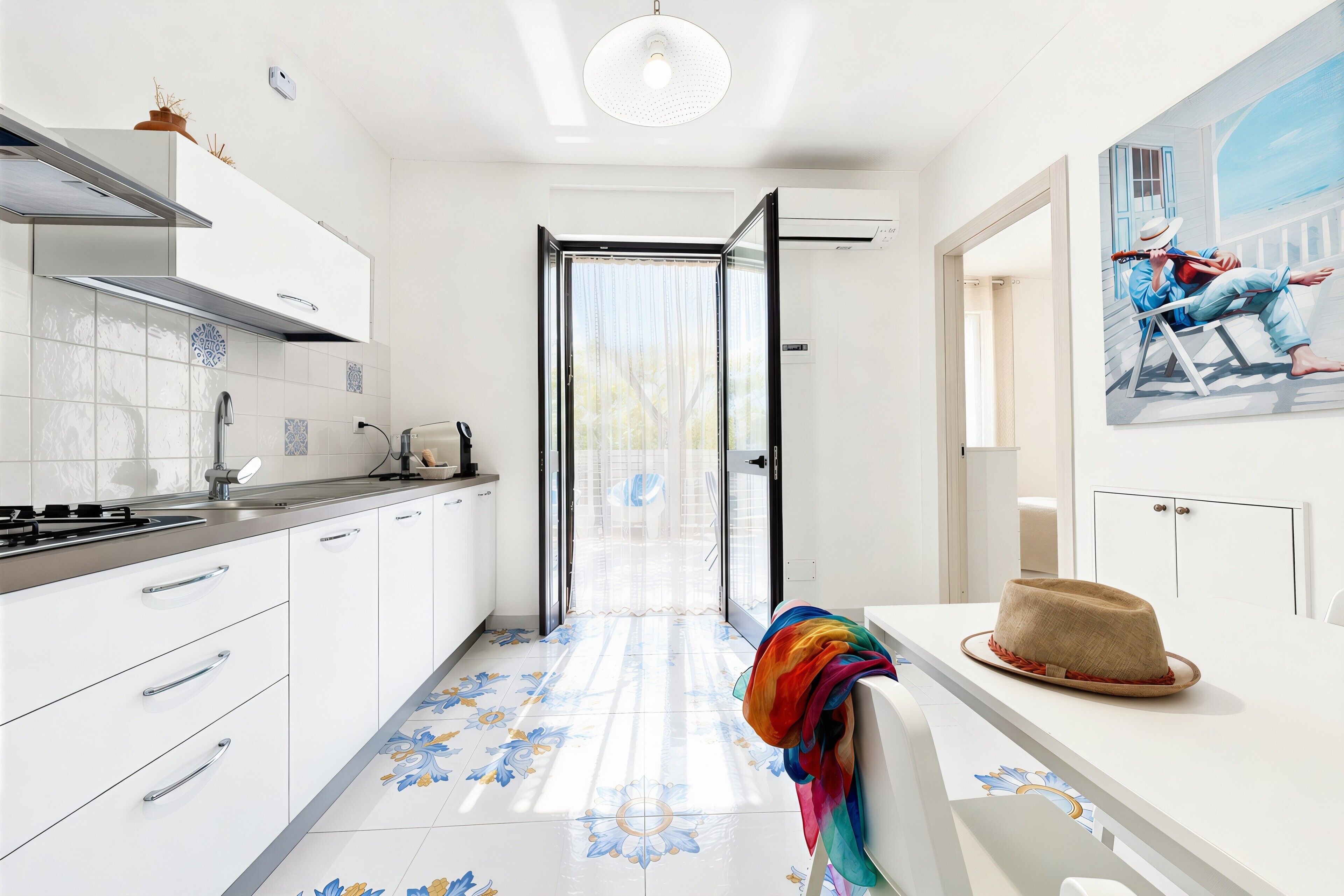 Una cocina moderna con armarios blancos, salpicadero de azulejos y vistas a través de un ventanal.