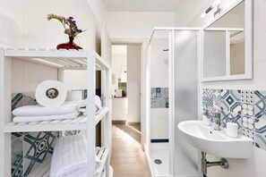 A modern bathroom with a shower, sink, and towel racks. - Apartment 'Le Case Di Chri' with Wi-Fi and Air Conditioning (Mattinata)