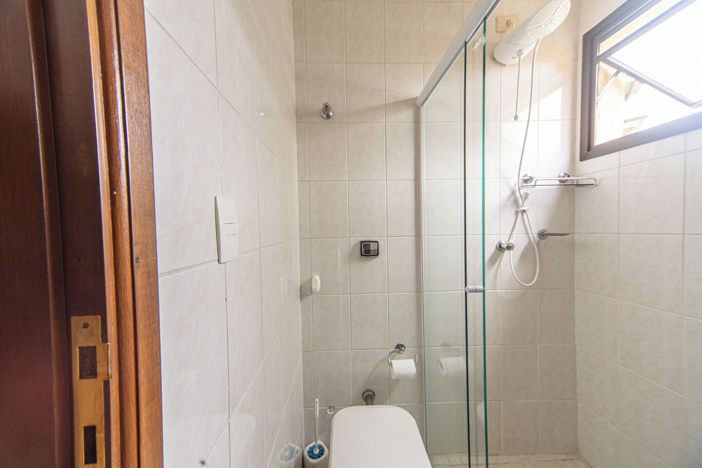 Um banheiro moderno com box de vidro, vaso sanitário e bidê.