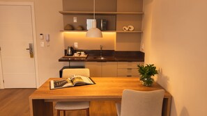 Una cocina moderna con comedor, que incluye una mesa de madera, sillas y una planta en maceta.