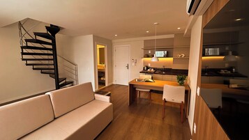 Una sala moderna con una escalera, una zona de comedor y una cocina.