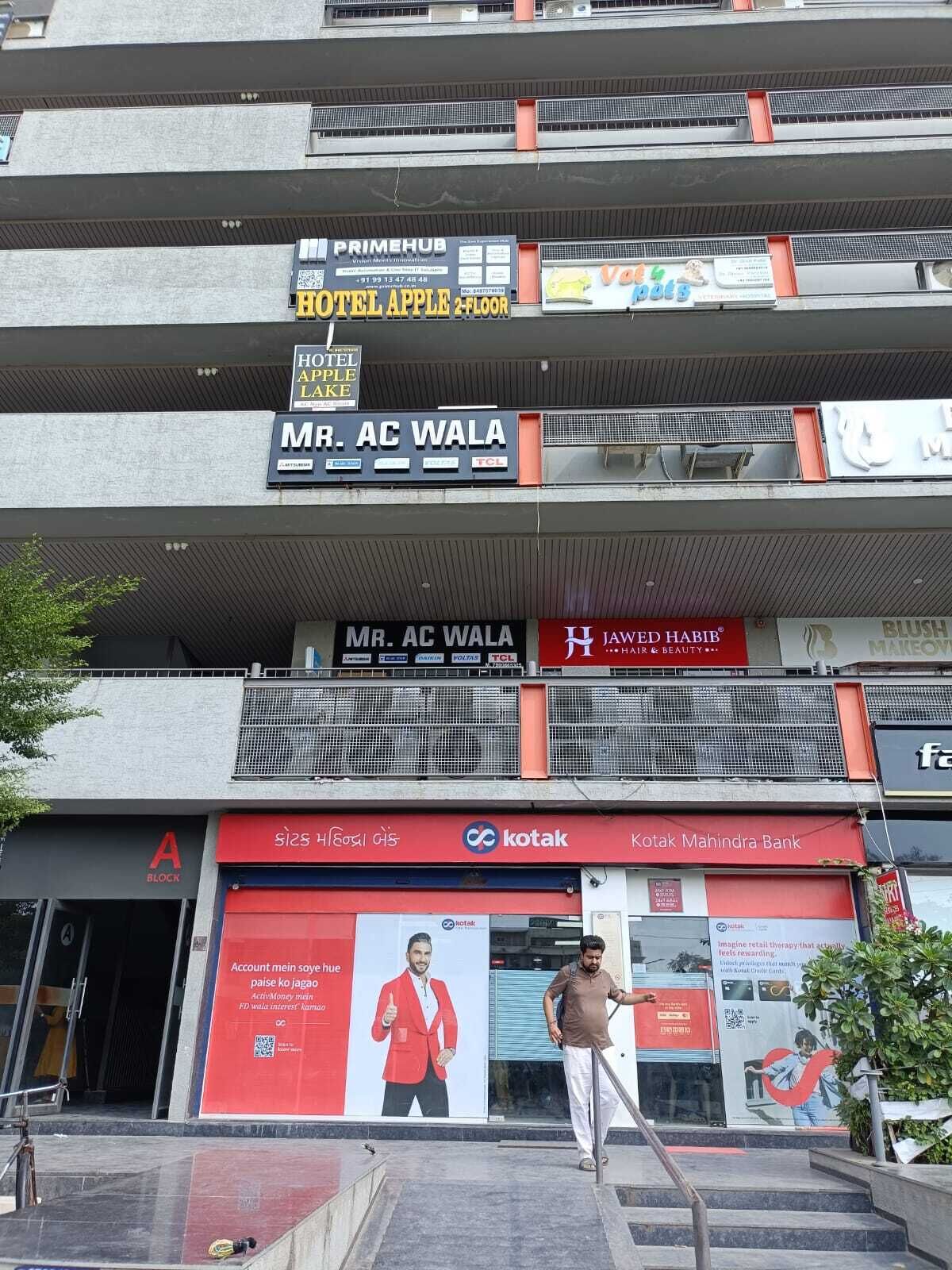 A multi-story building with various businesses including a hotel, a bank, and a beauty salon.