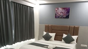 Ein modernes Schlafzimmer mit einem großen Bett, einem Nachttisch, einem Sessel und einem Deckenventilator.
