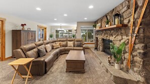 A spacious living room with a large L-shaped sectional sofa, a wooden coffee table, and a stone fireplace. - Cr2232k-2 (Keystone)