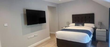 Tabla de planchar con plancha, acceso a internet y ropa de cama