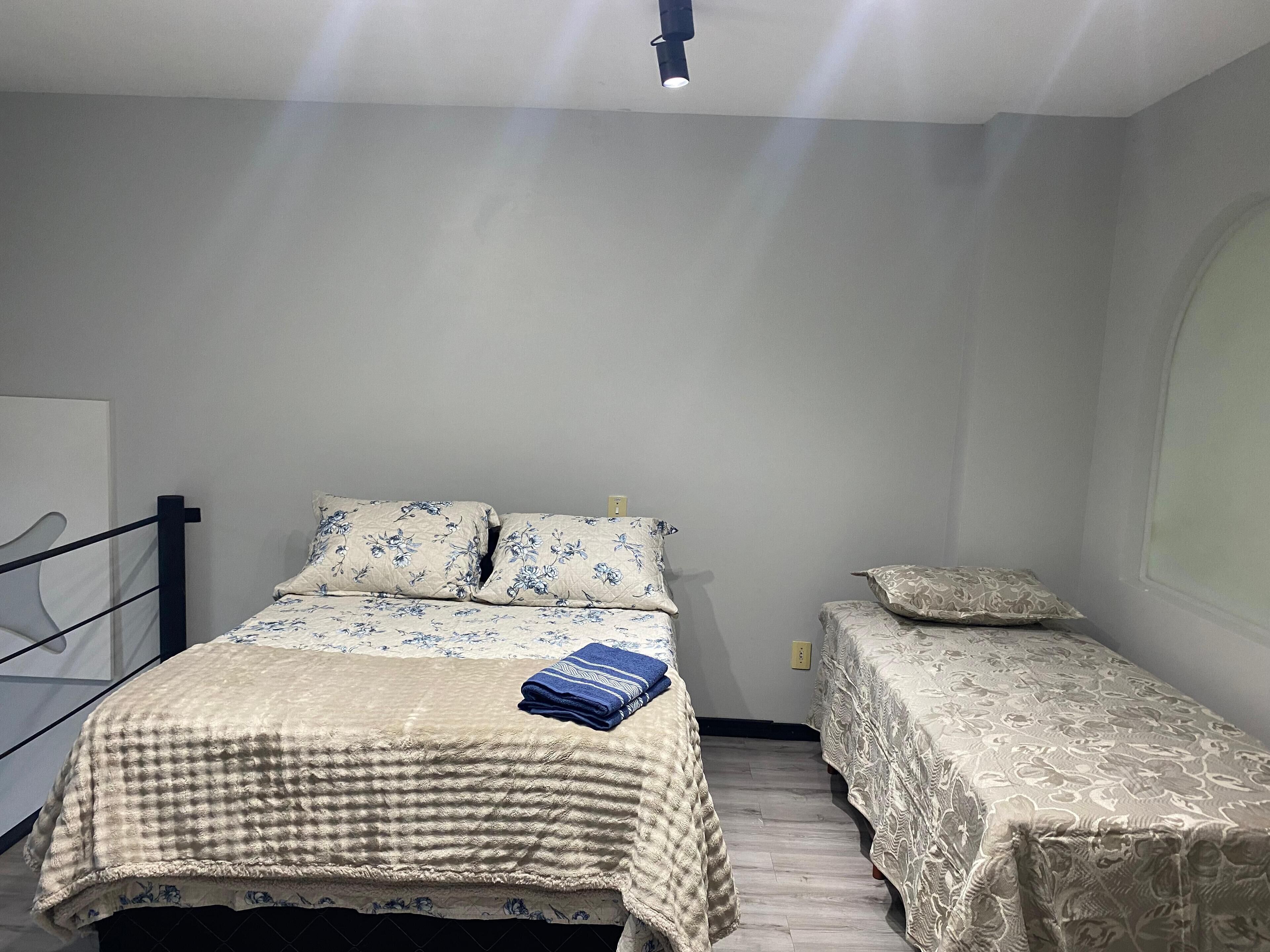 Ein Schlafzimmer mit einem Bett, zwei Nachttischen und einem Fenster.
