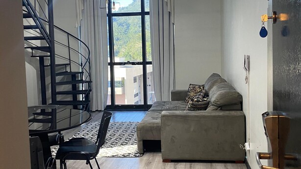 Un salon moderne avec un escalier, un canapé et un coin repas.
