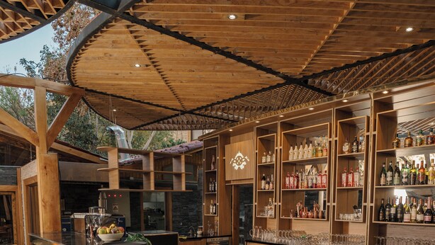 Eine Bar mit Holzbalken, einer Ziegelwand und einer Bar mit Hockern.