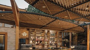 Eine Bar mit Holzbalken, einer Ziegelwand und Barhocker.
