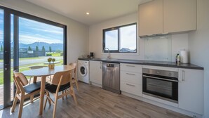 Una cucina moderna con lavastoviglie, forno e un'ampia finestra che si affaccia su un panorama suggestivo.