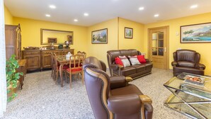 Una sala de estar con comedor, un sofá, una mesa de centro y una chimenea.