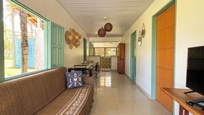 Una sala de estar con sofá, televisión y un comedor con mesa y sillas.