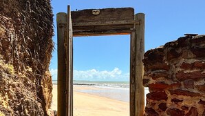 Una puerta que da a una playa con cielo despejado.
