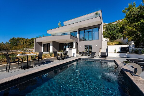 A modern two-story house with a swimming pool, outdoor seating, and a mountain backdrop. - Starigrad Villa With Private Wellness Center (Starigrad)