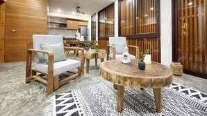 Un soggiorno moderno con mobili in legno, un tavolino rotondo in legno e un tappeto decorato.