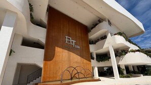A modern building with a prominent wooden panel and the text "VISTA CAPITAL GROUP 326". - PH de 2 rec, gim, cine y jacuzzi privado en Tulum (Tulum)