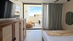 A hotel room with a bed, a TV, a wooden cabinet, a balcony with a view, and a ceiling fan. - PH de 2 rec, gim, cine y jacuzzi privado en Tulum (Tulum)