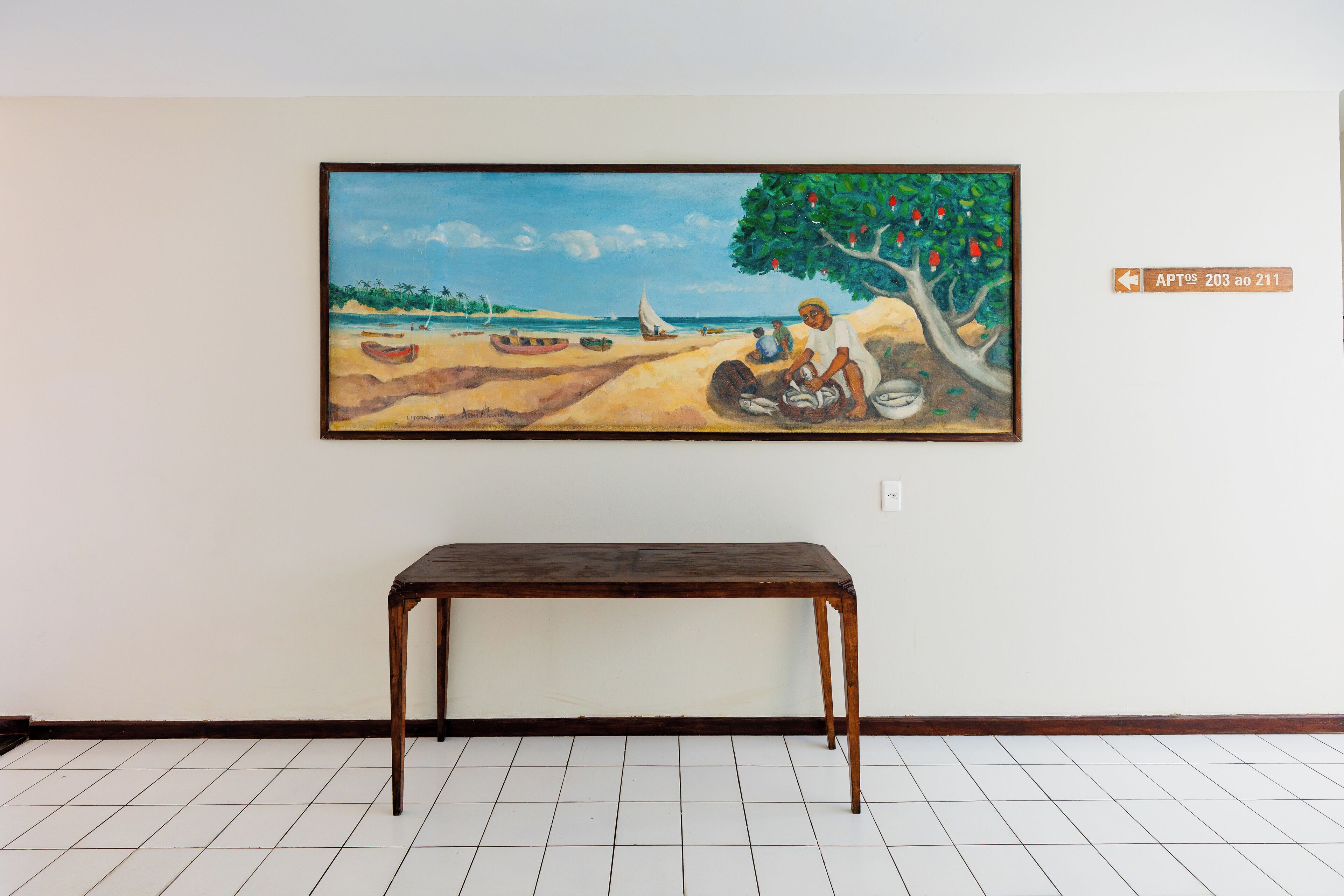 Un tableau représentant une scène de plage avec une table au premier plan.