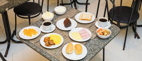 Ein Esstisch mit verschiedenen Frühstücksangeboten, darunter Toast, Eier und Kaffee.