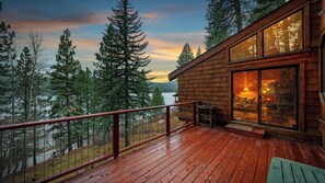 A wooden cabin with a deck overlooking a lake, surrounded by trees. - Cozy Donner Lake Cabin w/ Kayaks, Forest Views, Fireplace & Quick Ski Resort Access Donner Lake Refuge by Avantstay (Truckee)