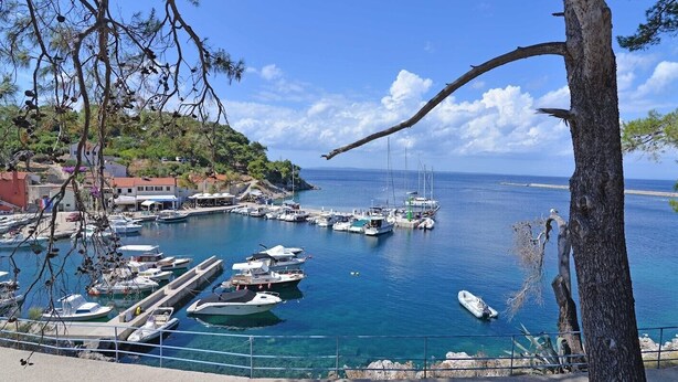 A marina with boats docked, a clear blue sky, and buildings in the background. - Antunovic / Antunovic 1 (Veli Lošinj)