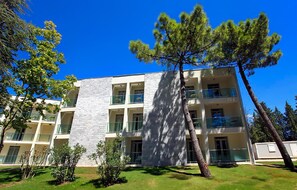 A multi-story building with a white facade and balconies. - Lovely apartment in Biograd with sauna (Biograd)