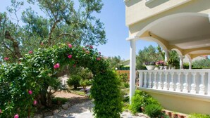 A garden with a pergola covered in pink flowers, a pathway, and a white railing. - Mobile homes Bella vita 3 (Biograd na Moru)