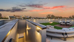 Terraço no telhado com lareira, área de estar ao ar livre e luzes de corda.