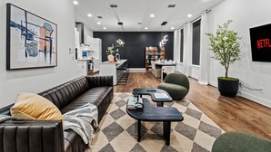 Uma sala de estar moderna com sofá, mesa de centro e TV fixada na parede.