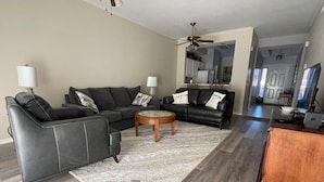 A modern living room with a sectional sofa, a coffee table, and a rug. - Legends Country Club Social 2/2 Condo Overlooking Hole #1, Close to Country Club (Fort Myers)