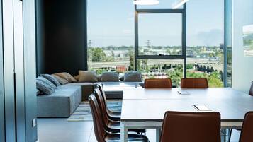 Una sala de reuniones moderna con una mesa grande, asientos cómodos y vistas de la ciudad a través de amplias ventanas.