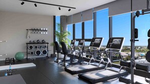 Un gimnasio moderno con cintas de correr, pesas y un amplio ventanal con vistas a la ciudad.